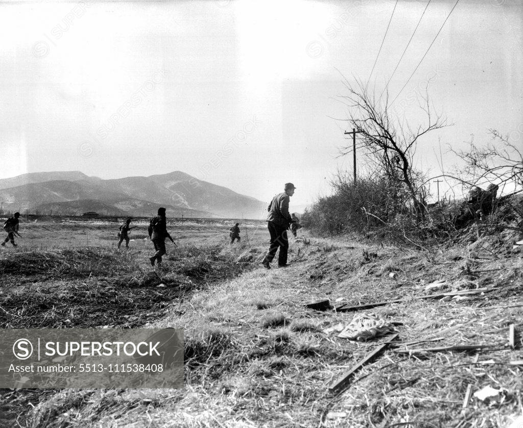 Stock Photo: 5513-111538408 A Day with the 25th (Sixth of Ten) - Moving along the front across an open field from one point of cover to another, a patrol goes quickly but cautiously for the enemy might still be lurking in the bushes. February 3, 1951. (Photo by ACME).