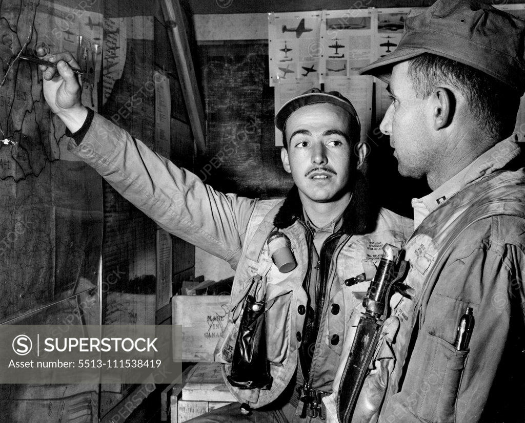Stock Photo: 5513-111538419 Marine Corps Night Fighters in Korea - Warrant Officer Robert B. Woodworth, USMC of 107 Westwood Ave., Pittsburgh PA. (left) prepares for his 37th night fighter mission by checking points to be covered with the pilot, Capt. Edward Long, USMC of 38 Broadway St., Costa Maga, Cal who flies the F7F in the black night over Korea to keep to enemy under constant harrassment. In a short while, Long and Woodworth will man their plane with the others of Marine Squadron VMF 513 and start their deadly patro