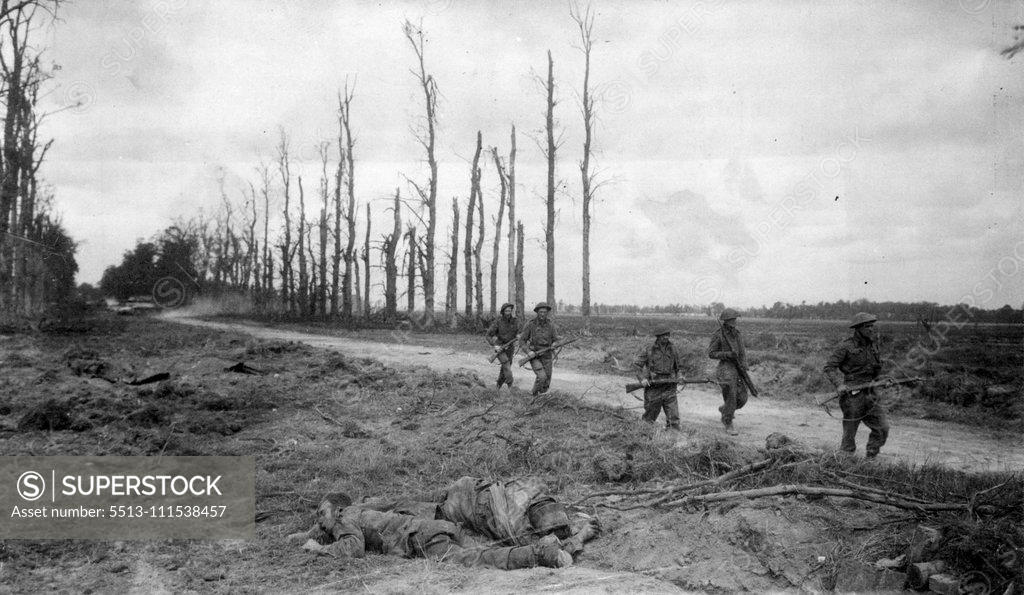 Stock Photo: 5513-111538457 The Grimness of the Battle for Caen: British troops passing dead Germans after clearing snipers from a village on the outskirts of Caen. July 11, 1951. (Photo by Associated Press Photo).