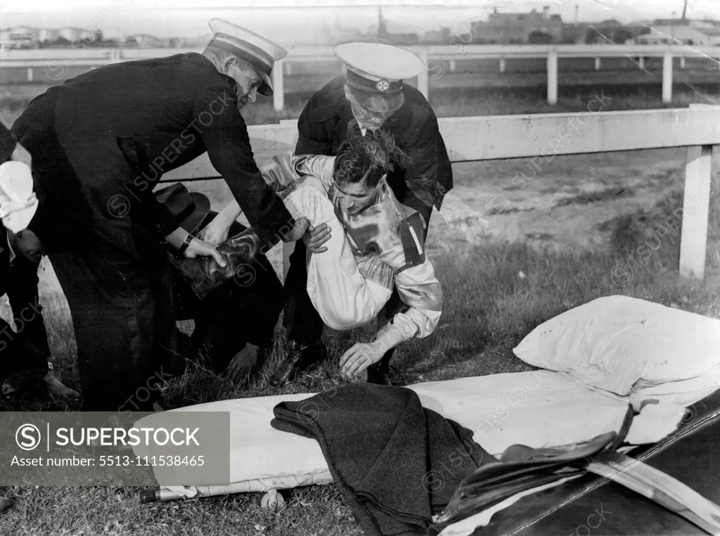 In pain, leading jockey, J. Thompson, is lifted from ***** track by ambulancemen after his crash from Prince Dakhill in ***** Rosehill Handicap today. Prince Dakhill was killed and ***** Thompson was taken to Parramtta Hospital with a broken leg. June 13, 1953.