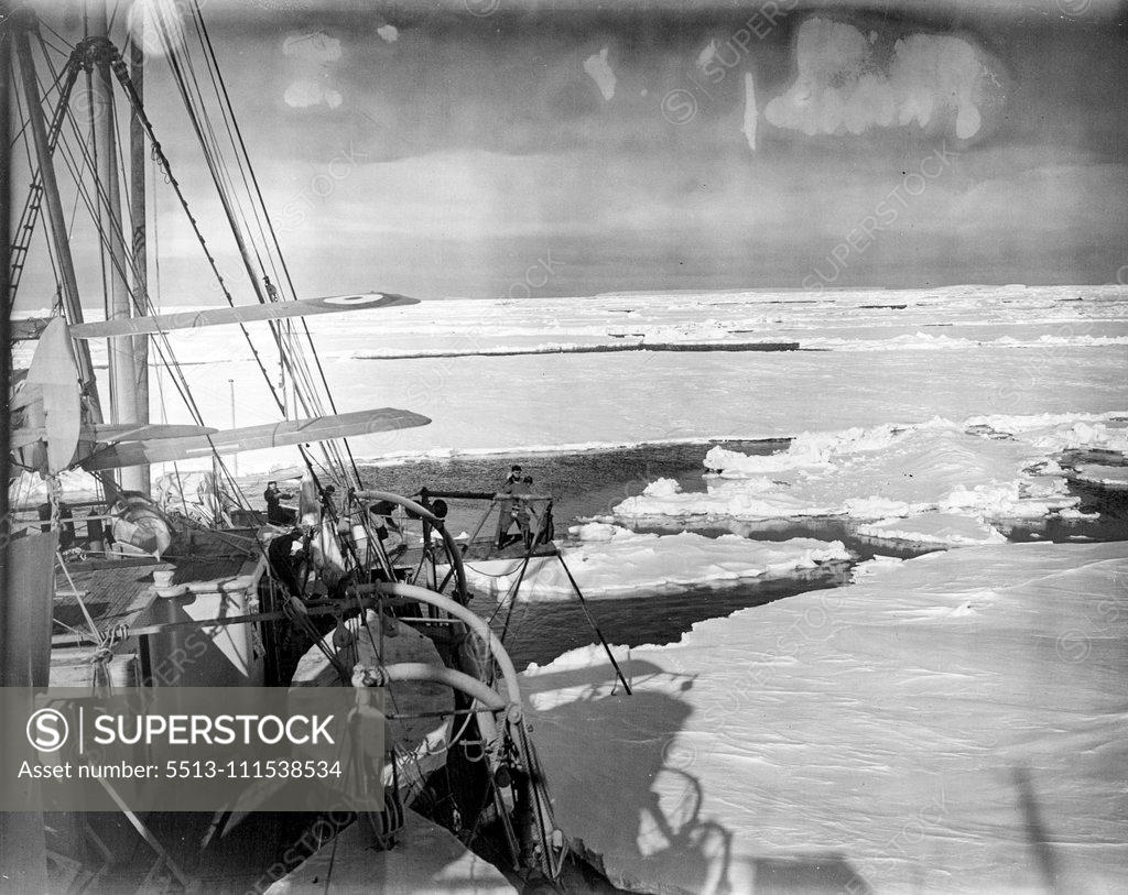 Stock Photo: 5513-111538534 Pushing Aside great ice floes the Discovery II. made her way into the southern wilderness to rescue the missing American explorers. The two figures on the platform with the pole are trying to keep the ship clear of floes. Note the search plane. January 1, 1950.