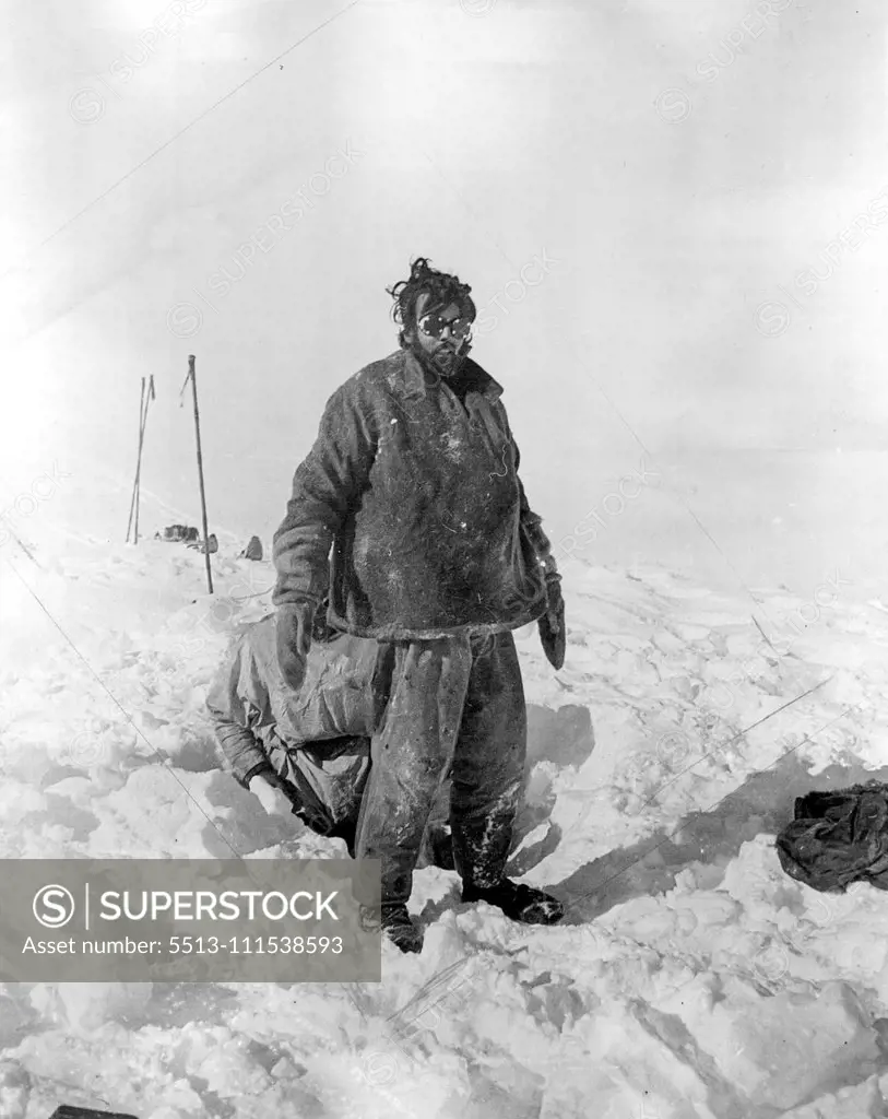 British Arctic Air Route Expedition: Courtauld immediately after emerging from top of tent. Rymill in hole over tent behind Courtauld. May 29, 1931. (Photo by Mr. F. S. Chapman, British Arctic Air Route Expedition Photograph).