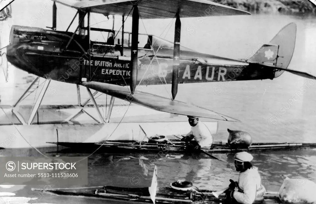 British Arctic Air Route Expedition: One of the Moth aeroplanes on floats, with two Eskimos in their Kayaks. December 28, 1931. (Photo by British Arctic Air Route Expedition Photograph).