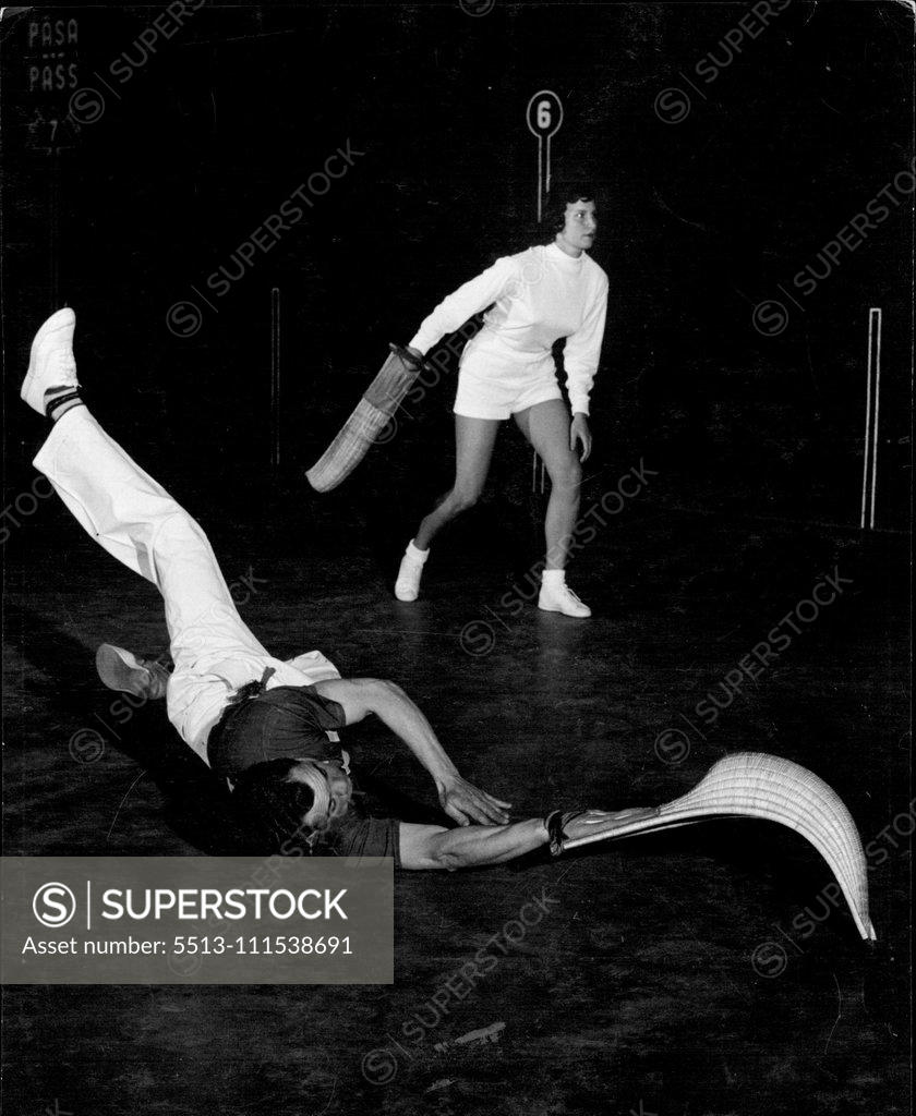Stock Photo: 5513-111538691 Girl "Jai-Alai" Players (9): You don't only have to climb walls but you also have to scramble on the floor sometimes, when playing Jai-Alai. This action shot has caught pro player Tiburcio Celaya who has dived on floor to snare a low shot and made a return. Alicia Weeks, in back ground, braces herself to return Celaya's shot. April 1, 1954. (Photo by Ben & Sid Ross).