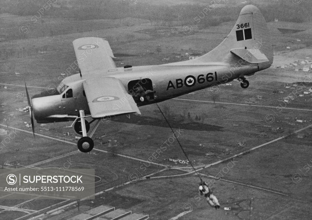 Stock Photo: 5513-111778569 New All-Purpose Plans. A parachutist of the R.C.A.F. demonstrates one of the many uses for the new Canadian "Qtterr" all-purpose 'plane. A second parachutist can be seen just about to jump from the 'plane. The "Otter" 'plane, which has been designed and built in Canada by the De Havilland Company, for use in the Northland areas, has been officially received into service. Besides being a troop carrier, the extremely short take-off and landing space required by the "Ottar", enables it to be used f