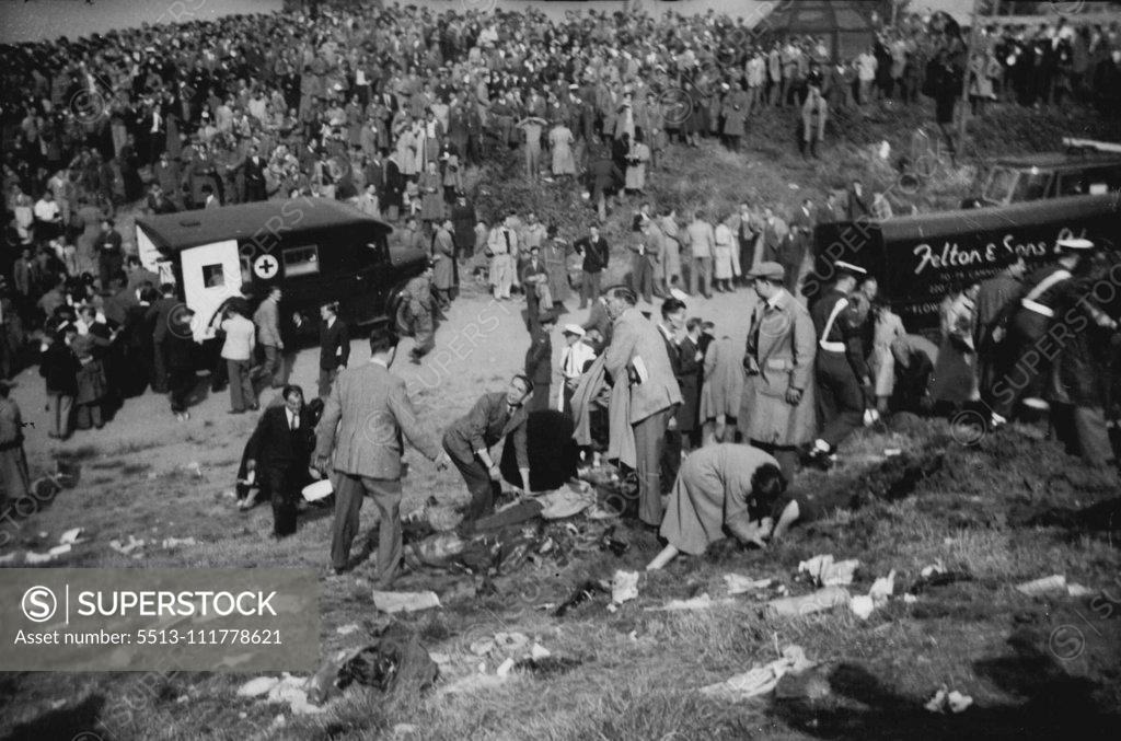 Stock Photo: 5513-111778621 When Death From The Air Struck The Farnborough Hillside The grim scene on the hillside where the spectators were killed and injured casualties lie on the ground as first and is given. In background is an ambulance and a crowd which seams bewildered and stunned. Twenty persons - pilot John Derry and a passenger and 18 spectators were killed and 35 spectators were injured when the No. 1 prototype of the semi-secret De Havilland 110 all-weather jet fighter blew up at the Farnborough (Hampshire) air