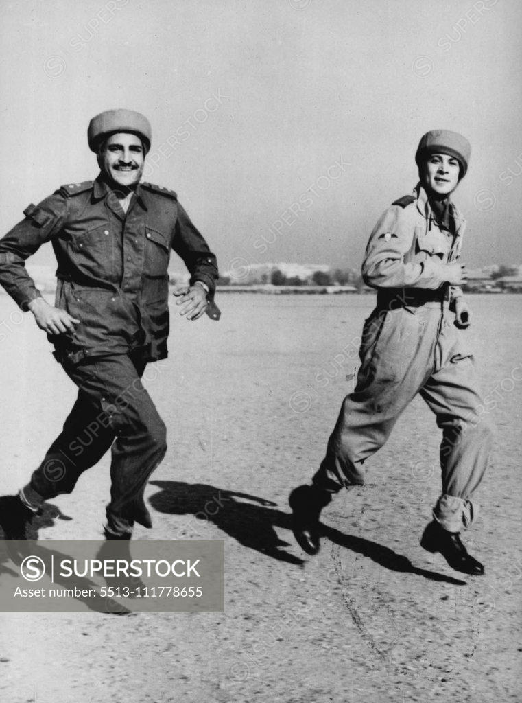 Stock Photo: 5513-111778655 Egyptian Paratroopers Stage First Mandeuvers Captain Steimel (right, first name not available), German Instructor, runs to the waiting aircraft with an Egyptian paratrooper, during the first manoeuvres of the newly created Egyptian paratroop unit, November 29th. A Dakota aircraft of the Egyptian Royal Air Force took off from the Almaza Military Airport, with four Egyptian parachutists during the manoeuvres and later the parachutists baled out over a field. German experts who for several months h