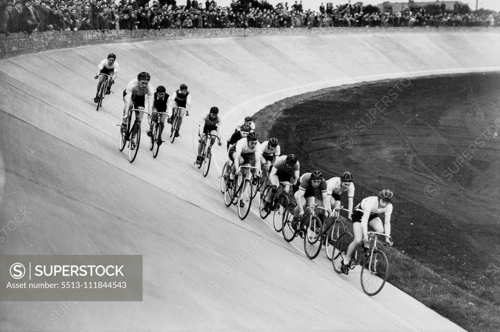 Stock Photo: 5513-111844543 Progress of Britain's New Sport - Cyclists competing at a meeting of the Manchester Track Racing League on the new Fallowfield track, as an excited crowd lines the top of the banking. A cinder track for foot events can be seen on right. It is expected that all existing British cycle records will be broken on the new Continental-style track now in use at Fallowfield, Manchester. It is to be opened officially next month, when cycling stars from all over Europe will compete. The tracks, with steep 