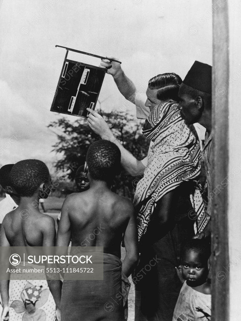 Stock Photo: 5513-111845722 Do African Children Grow Up Quicker ? -- X-ray plates of their hands hold the Wadigo boys entranced, but the little girl finds the photographer more interesting. September 17, 1951. (Photo by Central Office of Information Photograph). ;Do African Children Grow Up Quicker ? -- X-ray plates of their hands hold the Wadigo boys entranced, but the little girl finds the photographer more interesting.