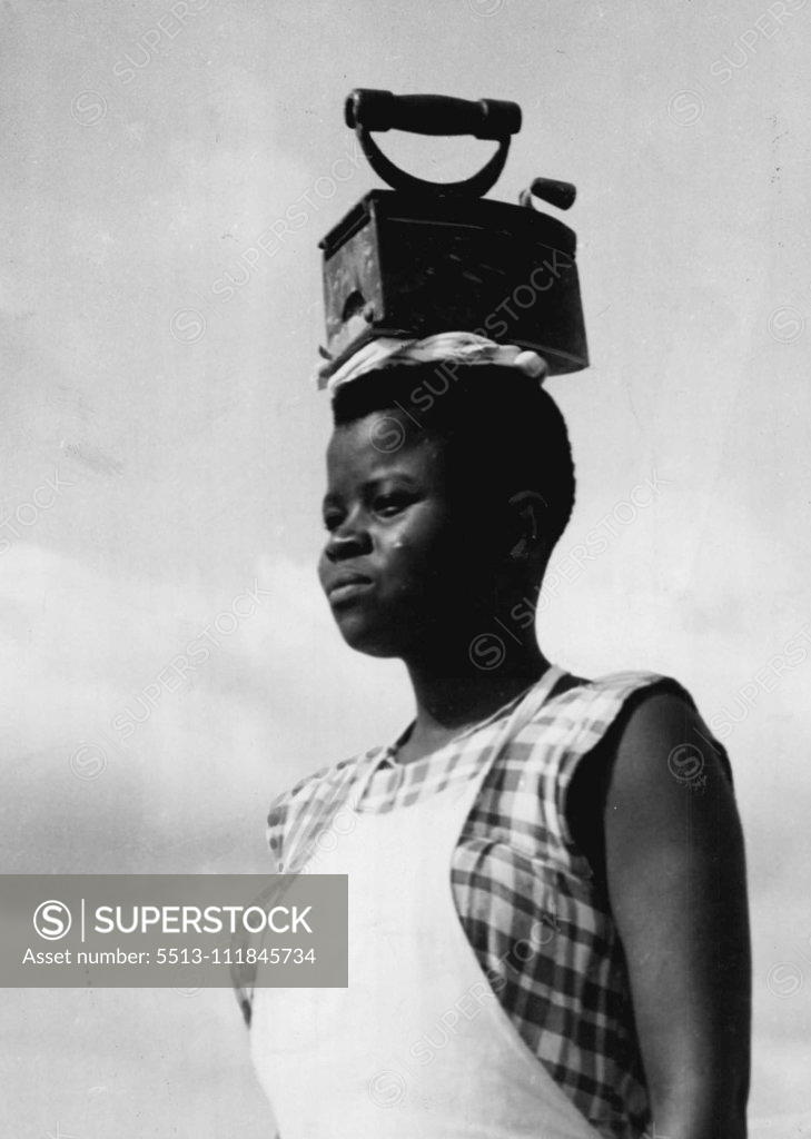 Stock Photo: 5513-111845734 No She's not practicing deportment. She's on her way to a domestic science class at a Baptist Mission school near Thysville, Belgian Congo. And since there's no gas or electricity laid on in the bush she's got to heat her flat iron on hot charcoal. June 17, 1953. (Photo by Daily Mirror).;No She's not practicing deportment. She's on her way to a domestic science class at a Baptist Mission school near Thysville, Belgian Congo. And since there's no gas or electricity laid on in the bush she's got t