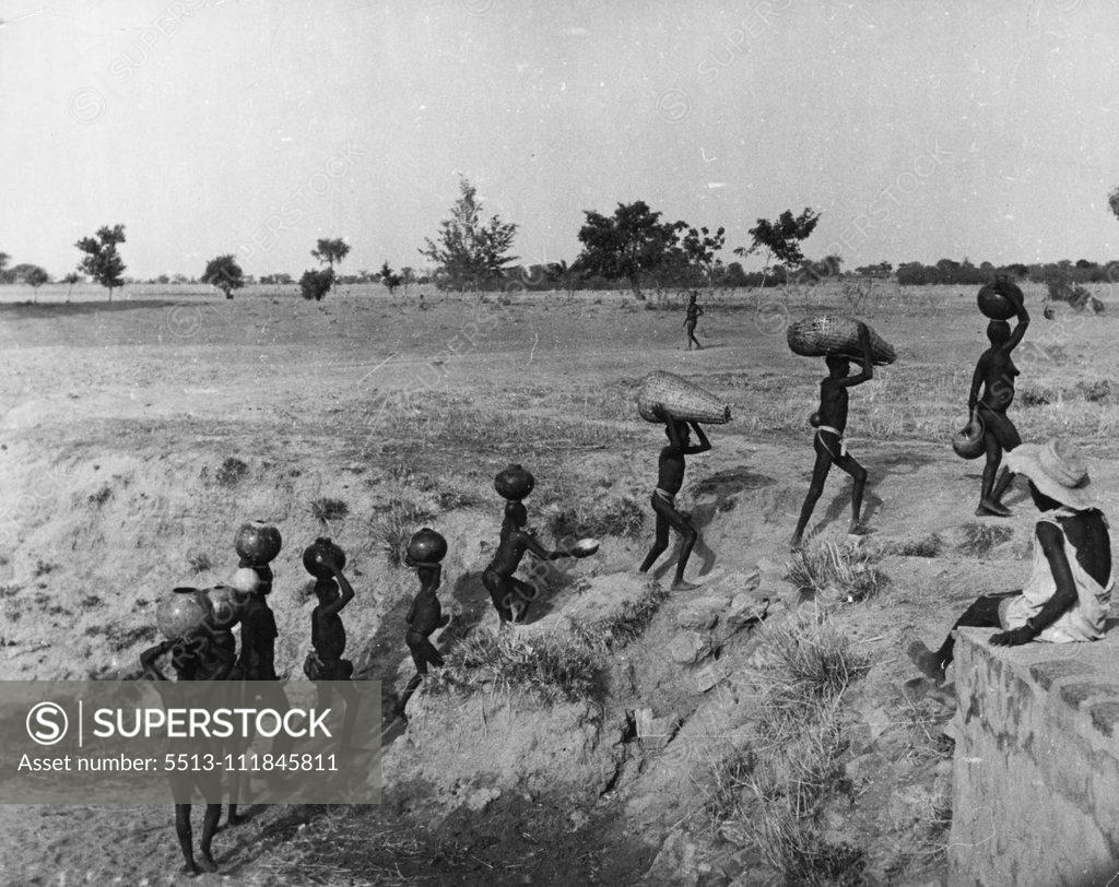 Stock Photo: 5513-111845811 Pagans of the Northern Territories, Gold Coast: The Furafuras At Work -- The women fetch water from the near-dry river bed. The wells are mostly dry and the people get their water by digging in the empty river beds. Often it takes an hour or more for to fill ten pots with water. April 23, 1951. (Photo by Pictorial Press).;Pagans of the Northern Territories, Gold Coast: The Furafuras At Work -- The women fetch water from the near-dry river bed. The wells are mostly dry and the people get their wa