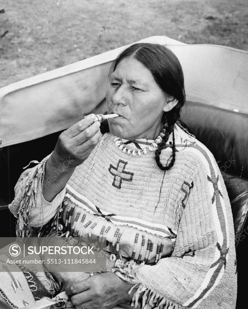Stock Photo: 5513-111845844 The End of A Perfect day -- Red Cloud Woman Lights her Cigarette with the lights from the swanky car they rented for the occasion and their Trip to tow. January 11, 1941. (Photo by Associated Press Photo).;The End of A Perfect day -- Red Cloud Woman Lights her Cigarette with the lights from the swanky car they rented for the occasion and their Trip to tow.