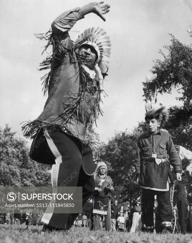 Stock Photo: 5513-111845850 Hi, Ho, Come To The Fair (Eleventh Of Fifteen) -- War dances by New York Indian tribesmen were a popular event every morning. Young "Warrior" (at right) seems fascinated by the gyrations of an older tribesman. September 23, 1949. (Photo by ACME).;Hi, Ho, Come To The Fair (Eleventh Of Fifteen) -- War dances by New York Indian tribesmen were a popular event every morning. Young "Warrior" (at right) seems fascinated by the gyrations of an older tribesman.