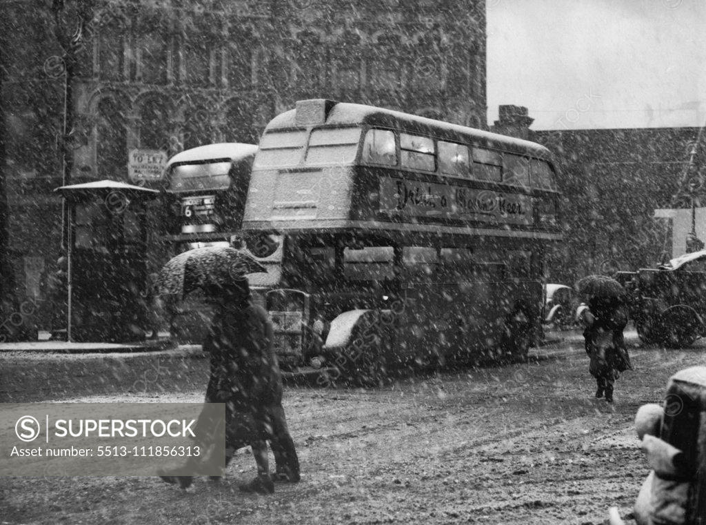 Stock Photo: 5513-111856313 Umbrellas Up - A bus makes its way through the driving snow in Ludgate circus this morning, Jan. 1st, and pedestrians hold their umbrellas at a slant to protect their faces. Picture taken during the small-scale blizzard that hit London. January 19, 1951. (Photo by Associated Press Photo).;Umbrellas Up - A bus makes its way through the driving snow in Ludgate circus this morning, Jan. 1st, and pedestrians hold their umbrellas at a slant to protect their faces. Picture taken during the small-scale