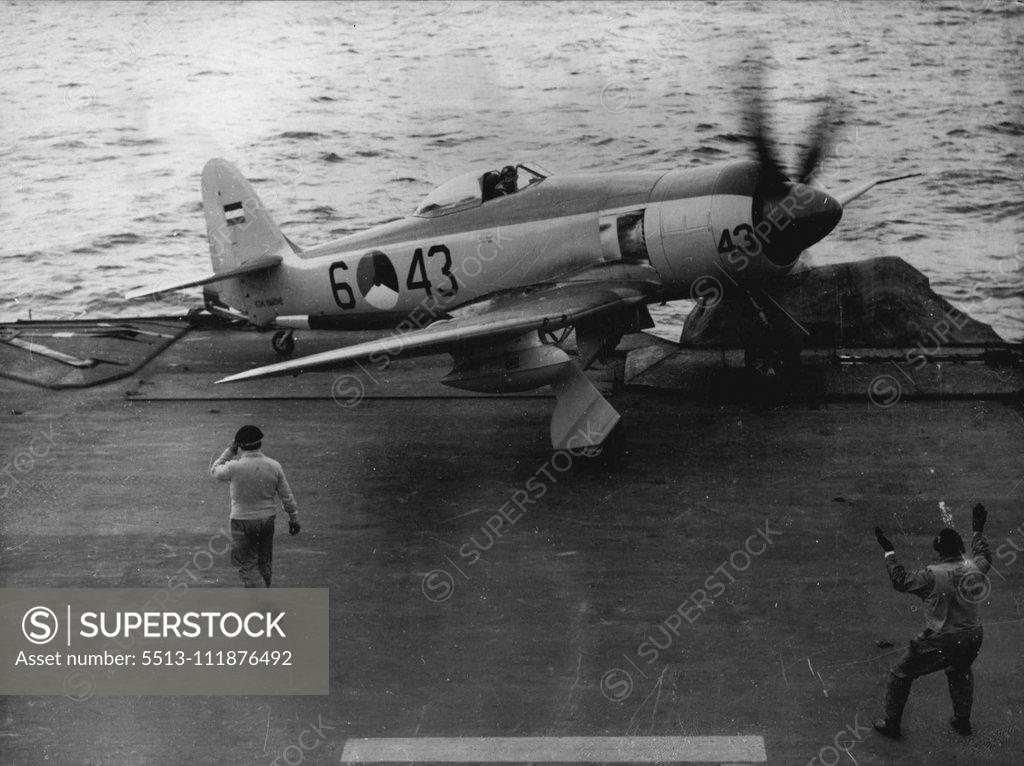 Stock Photo: 5513-111876492 Near Thing -- A Dutch Royal Air Force Hawker Sea Fury plane nearly goes over the side of the flight deck of the British Aircraft carrier, H.M.S. Illustrious, after a patrol in the north Atlantic during the giant NATO "operation mainbrace." The flight deck officer (right) coaxes the pilot away from the edge. Over 150 warships are taking part in the operation designed to test the defence of Northern Europe. September 21, 1952. (Photo by Associated Press Photo). ;Near Thing -- A Dutch Royal Air F