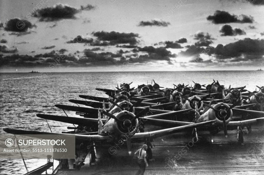 Stock Photo: 5513-111876530 Sunset On The Pacific -- As several flights of fighter planes are tied down on the flight deck, a U.S. Navy aircraft carrier plows through the Pacific, a cloud-studded sunset astern. In the distance, two more U.S. ships sail along the horizon. January 01, 1943. (Photo by Interphoto News Pictures, Inc.).  ;Sunset On The Pacific -- As several flights of fighter planes are tied down on the flight deck, a U.S. Navy aircraft carrier plows through the Pacific, a cloud-studded sunset astern. In the di