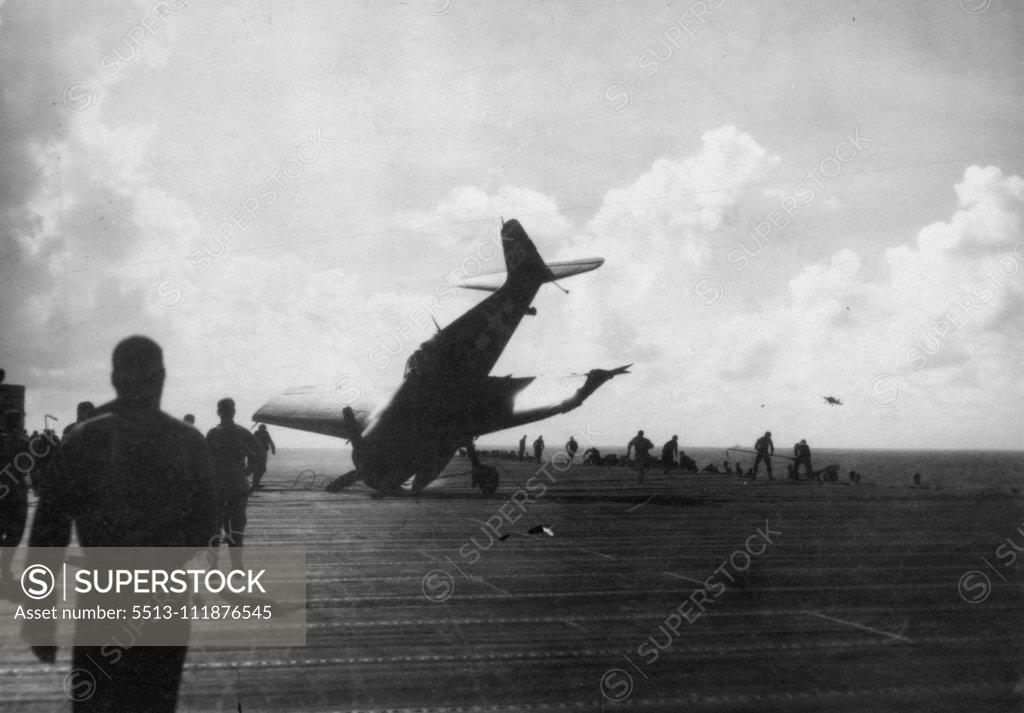 Stock Photo: 5513-111876545 Pilot Escapes Injury In Crash Landing -- Lt. Wendell Van Twelves of Spanish Fork, Utah, U.S. Navy pilot, made this spectacular crash landing *****an Essex-type carrier, almost ***** straight ***** crewmen who rushed ***** the plane to ***** found him ***** he was return from *****escorting Navy bombers over Manila. February 01, 1945. (Photo by Joe Rosenthal, Associated Press Photo).;Pilot Escapes Injury In Crash Landing -- Lt. Wendell Van Twelves of Spanish Fork, Utah, U.S. Navy pilot, made this