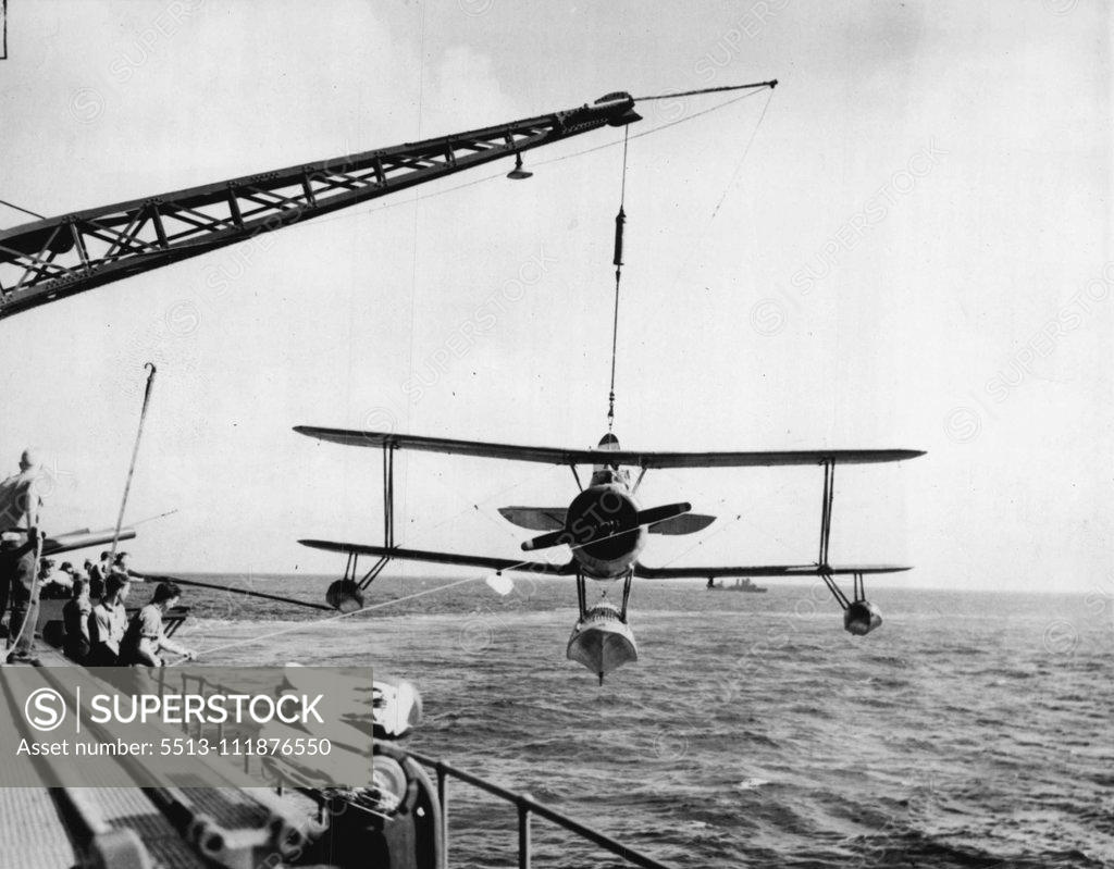 Stock Photo: 5513-111876550 A Seaplane Back To Roost -- A Seaplane is hauled aboard the heavy cruiser after its return from flight. These sturdily built planes are seldom damaged by the rough handling they must necessarily take. May 02, 1942. (Photo by Associated Press Photo). ;A Seaplane Back To Roost -- A Seaplane is hauled aboard the heavy cruiser after its return from flight. These sturdily built planes are seldom damaged by the rough handling they must necessarily take.