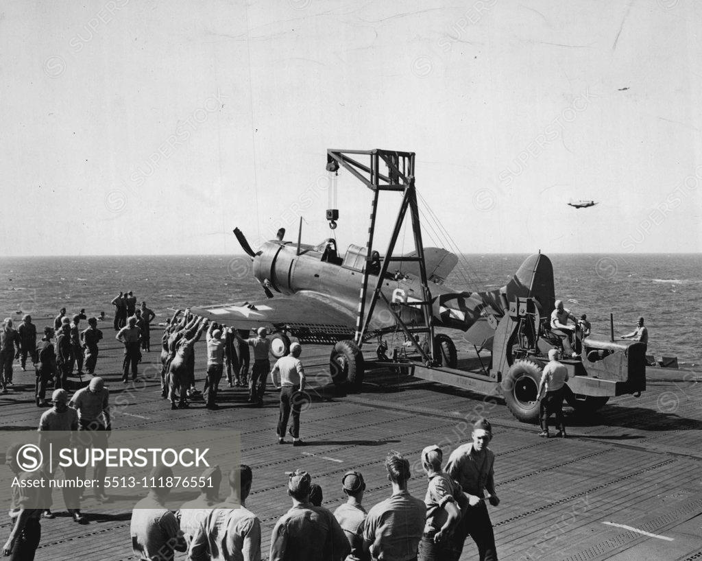 Stock Photo: 5513-111876551 ***** crash crane at work on a U.S. carrier removing an aircraft which cracked up. Pilot and gunner escaped injury. January 13, 1944. (Photo by Official U.S. Navy Photograph). ;***** crash crane at work on a U.S. carrier removing an aircraft which cracked up. Pilot and gunner escaped injury.