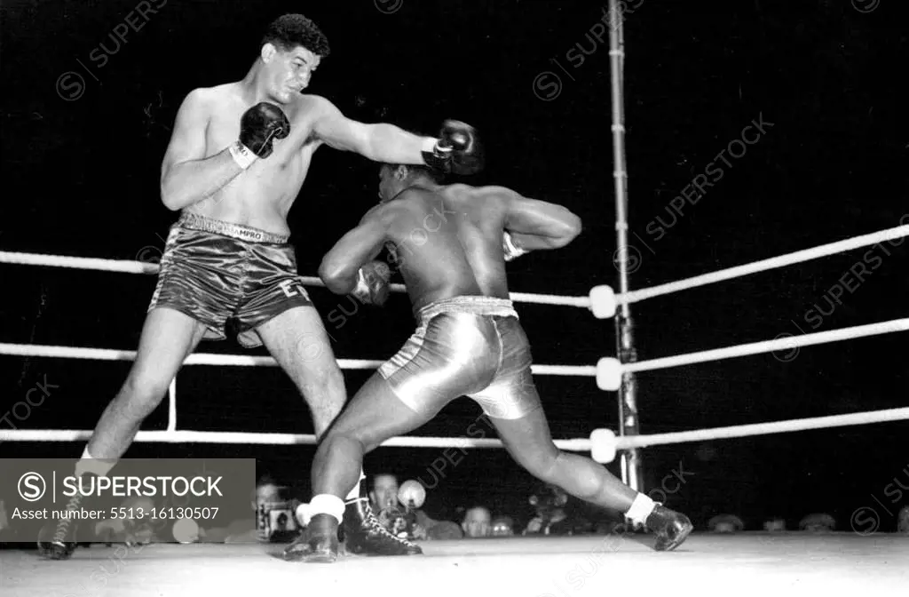 Giant South African boxer wins first fight in London. Templar slips under a straight left from his towering opponent. Ewart Potgieter the giant South African boxer defeated Simon Templar of Jamaica in their 8 round contest at the White City stadium, London. Templar - who could do little against his huge opponent - retired at the end of the 6th round after taking heavy ***** punishment. September 14, 1955. (Photo by Sport & General Press Agency, Limited).