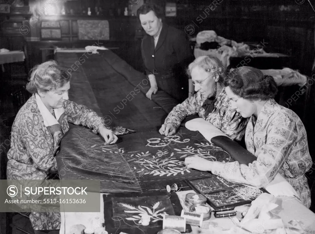 Queen's Coronation Robe Embroidered in London. Working on the embroidery of the Queen's Coronation robe at the Royal School of Needlework today. At left of table is Miss Violet Wise of Finchley, who worked on the Queen Mother's Coronation robe. Standing at right is the Head of the Workroom, Miss Rhoda Rasey (of Kingsbury). Miss M. Evans (Kensington), who also worked on the Queen Mother's robe; and Miss Margaret Bartlett of Leatherhad (nearest *****). February 11, 1953.
