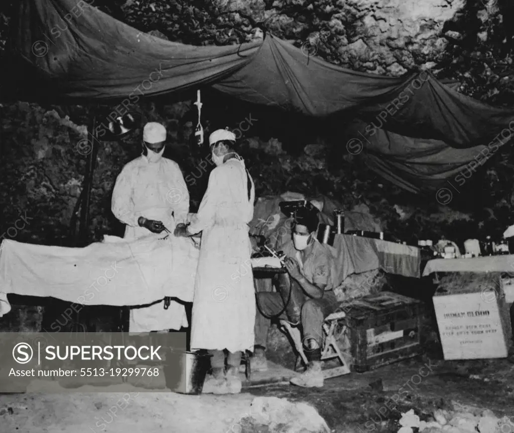 Captured Cave Used As Bomb-Proof Surgery -- left to right, Lt. Commander Robert J. Crawley, USNR, of New Orleans, La., surgeon in charge; Lt. (jg) Julius H. Dietz, of New York City; PhMI/c Roland M. Anderson, Duluth,
Minn,, administering anesthetic during an abdominal operation.
This cave taken from the Japs affords relative security peace and quiet to surgeons who perform many delicate operations on battle casualties while the battle for Okinawa rages around them. June 20, 1945. (Photo by Official U.S. Marine Corps Photo).
