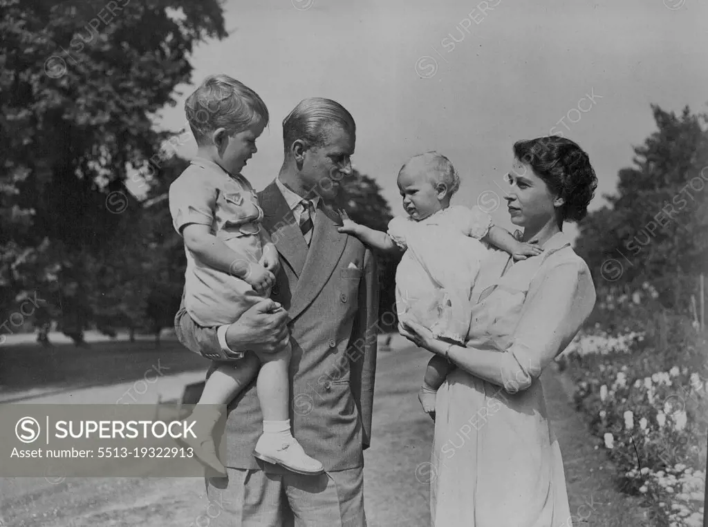 The Happy Family In Their Garden -- Princess Anne, held by her mother Princess Elizabeth, appears to be wanting to go to her father the Duke of Edinburgh who is holding Prince Charles.Pictures just released show H.R.H. Princess Elizabeth and the Duke of Edinburgh with their children Prince Charles and Princess Anne in the garden of the London Home Clarence House. August 09, 1951. (Photo by Barratts Photo-Press-Agency).