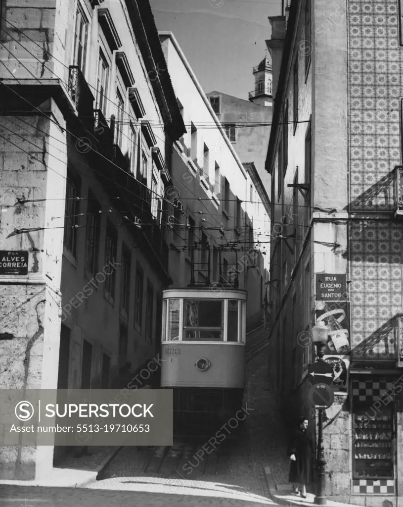 This is one of the six funicular (cable railway) lines connecting modern Lisbon with the ancient Alfama quarter of the city, which sits atop seven hills. Note the steep grade it climbs in this narrow street. The house at right has the colored tile decorations that are so prevalent in Lisbon. April 22, 1955. (Photo by United Press).