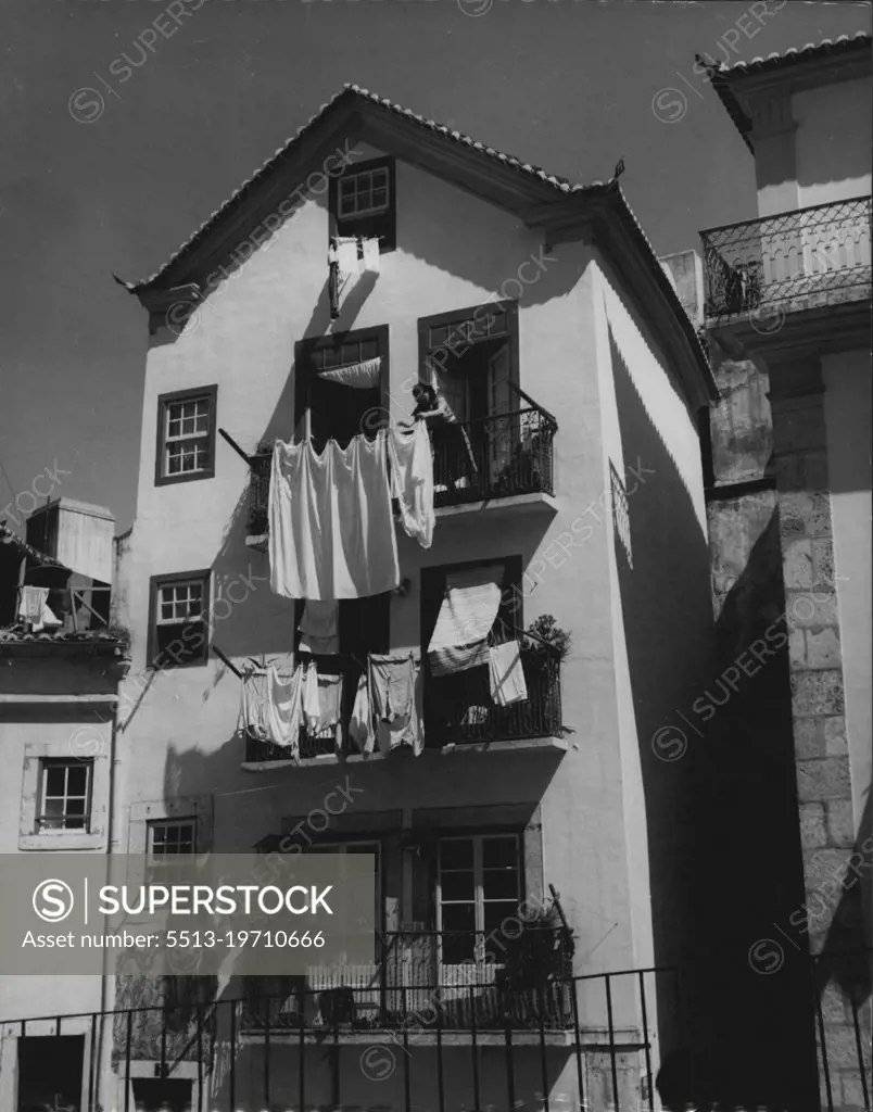 Lisbon 1952 -- A Lisbon housewife hangs her washing out to dry from the balcony of her lovely old house in the ancient quarter of "Alfama". February 27, 1952. (Photo by Sequeira, Camera Press).