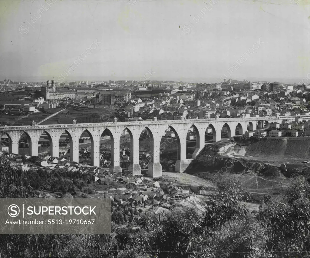 One of the most impressive sights of Lisbon is the ten-mile-long aqueduct, still carrying water into the city from the nearby hills. Three hundred feet high in some places, the picturesque structure dwarfs the suburban homes which nestle at its base. April 22, 1955. (Photo by United Press).