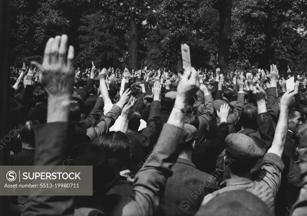 Dockers Stay Out - Government Moves In -- A forest of hands proclaims the intention of London dockers to stay out, in defiance of the Government's intention to declare a State of Emergency this morning July 11. They were voting at a mass meeting at Victoria Park Bethnal Green London, attended by about 5,000 dockers. The proclamation of emergency enables the Government to make emergency regulations to safeguard transport, food, water and other essential services. As the dockers' meeting ended, a member of the "Lock Out Committee" warned them to keep in close contact with the Committee, keeping themselves out of bother and trouble. July 11, 1949. (Photo by Associated Press Photo).
