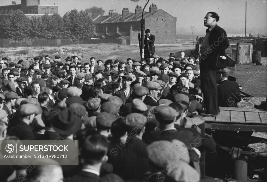 Dockers Hear 'Leader' On First Day of Emergency -- Crowd of London dockers listen to a speech by Albert Timothy, member of the unofficial 'lock out committee, at Royal.Victoria Dock to-day (Tuesday), first day of the State of Emergency regulations in the Port of London. More than 10,000 men are idle at the docks, and 112 ships are held up, owing to the refusal of the men to work the Canadian ships Beaverbrae and Argomont, which have been involved in a Canadian seamen strike. July 12, 1949. (Photo by Reuterphoto).