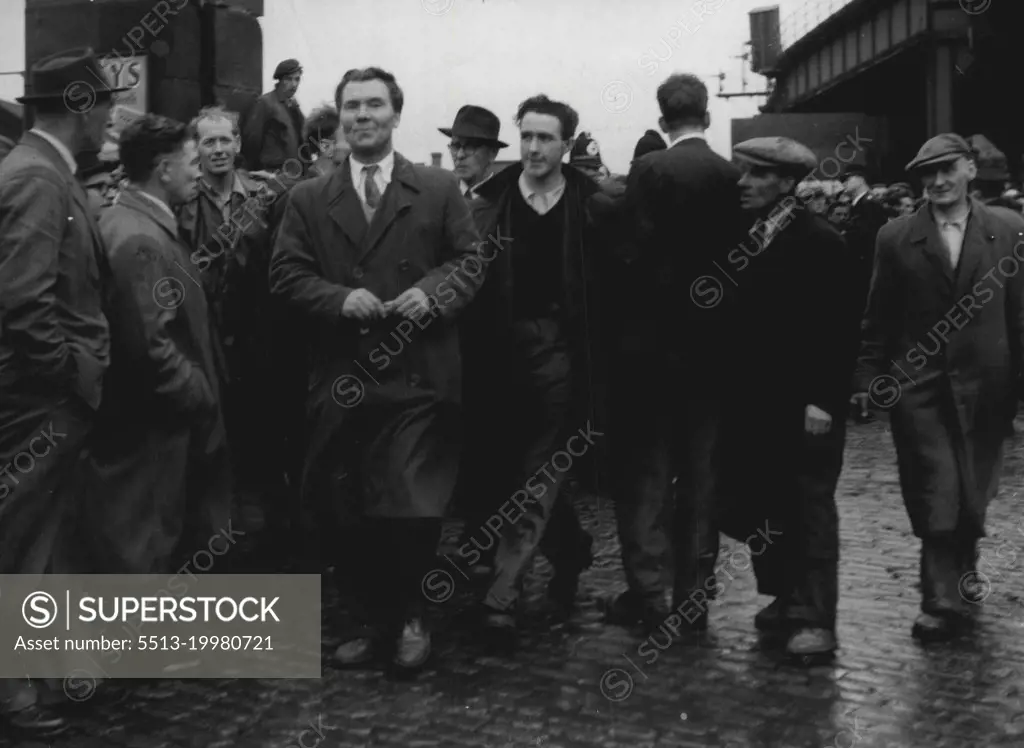 He Leads 'Work On' Move -- Bob Crosbie, 46 (in buttoned raincoat, centre), reports for work at the Gladstone Dock, Liverpool, after again persuading his followers at the dock not to strike. Extra police had been drafted to the Gladstone Dock to hold back more than 1,000 strikers who tried to block the dock rates. October 20, 1954. (Photo by Daily Mirror).