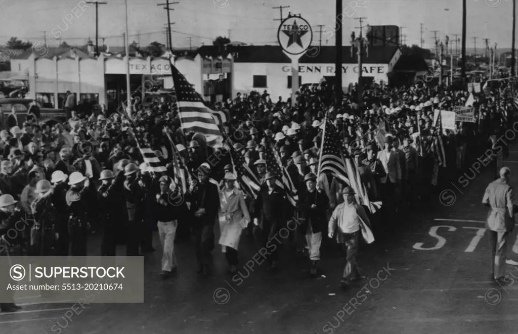 Deputies Salute Flag As Film Demonstrators March -- Deputy sheriffs salute the flag being carried at the head of a column of Labor demonstrators who marches nine times around Metro-Goldwyn-Mayer studio today before disbanding. The scene is the same as that where a bloody clash between the police officers and strikers occurred yesterday. October 2, 1946. (Photo by AP Wirephoto).