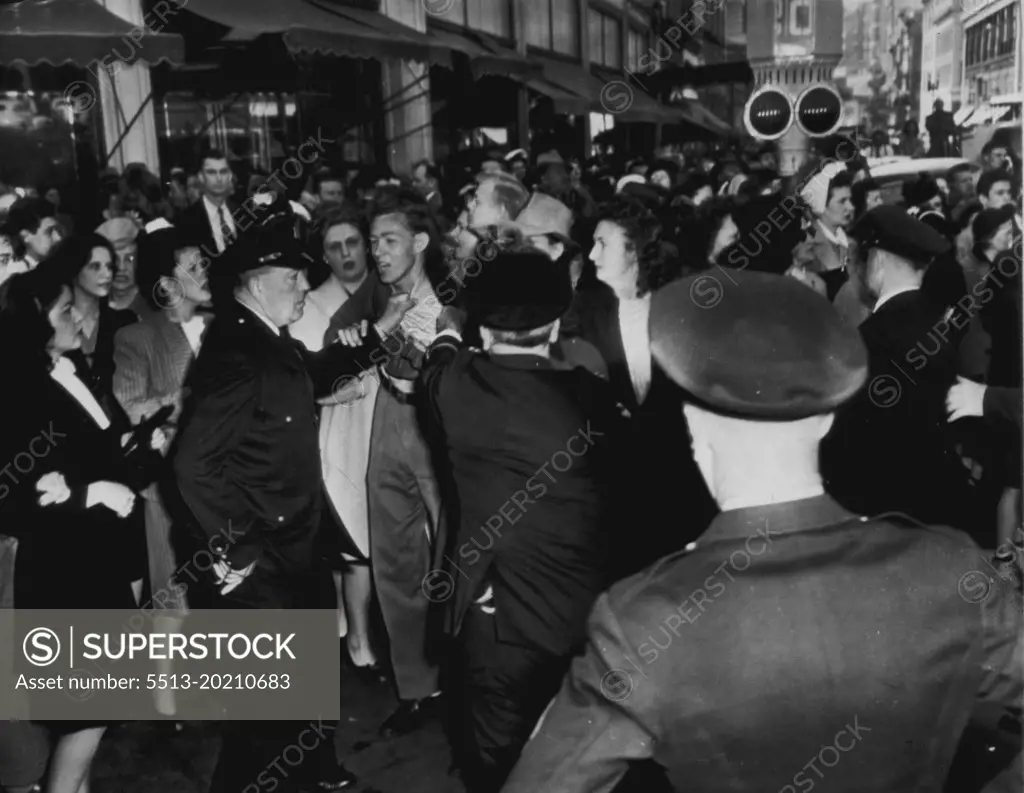 Police Hold Back Crowd -- An unidentified man (center) gets rough handling from police officers during a demonstration of striking telephone workers and sympathizers today. Several persons were arrested, police said, for "refusing to move on"! April 25, 1947. (Photo by AP Wirephoto).