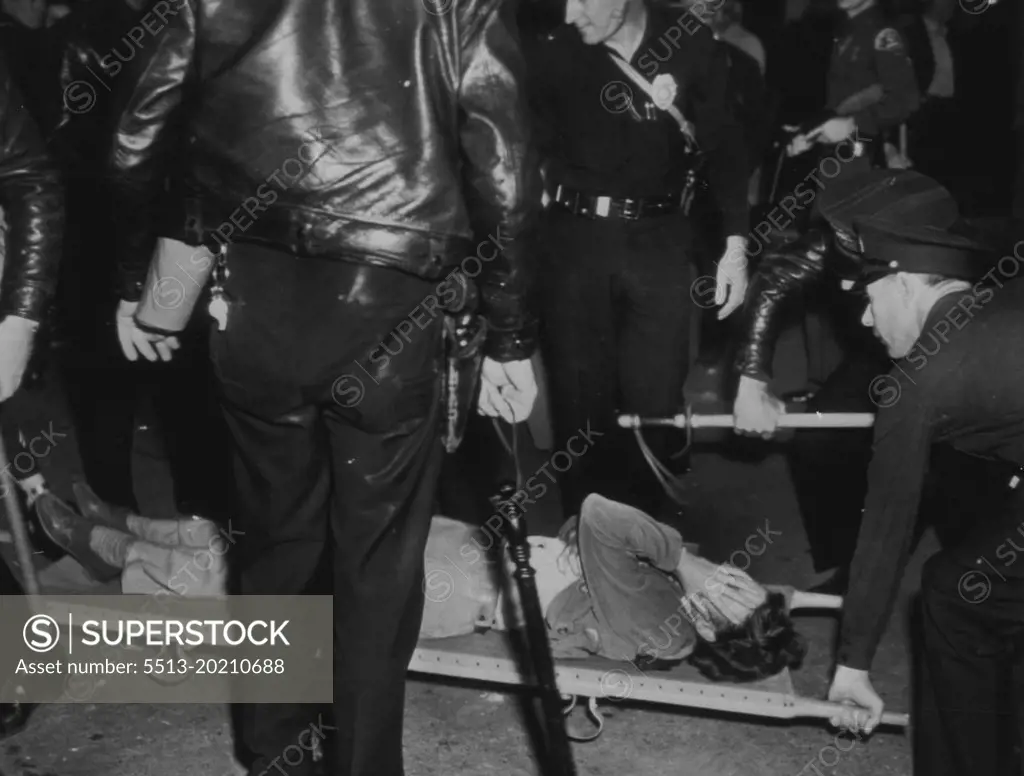 Picket Faints During Movie Strike -- The Excitement at Warner Bros. studio early today, when pickets and Non-strikers fought another battle at the studio gate, proved too much for this woman picket. She fell over in a faint and was taken inside the studio for first aid. October 8, 1945. (Photo by AP Wirephoto).
