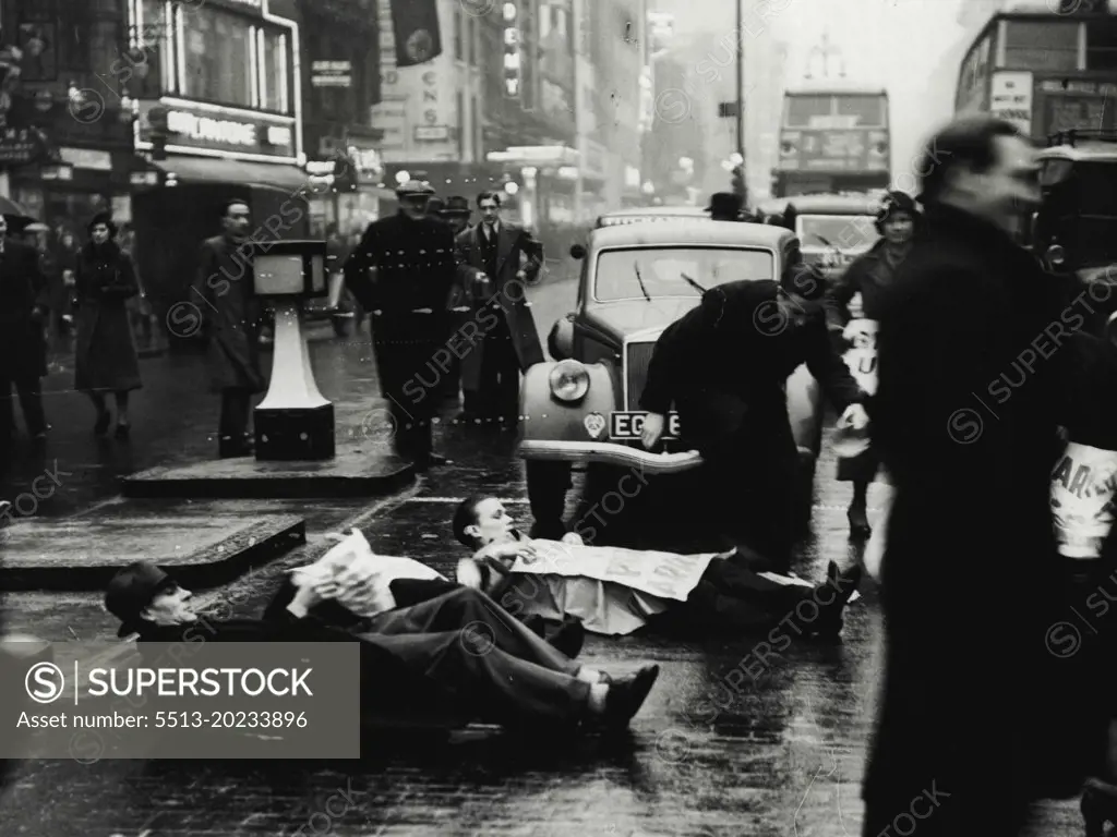 Unemployed Men Lie Down in Oxford Street -- The unemployed men lying in the road at the corner of Oxford Street and Berwick Street.Members of the Unemployed Workers Movement staged another demonstration today when they laid down in the road at the corner of Oxford Street and Berwick Street, Holding up the traffic until the police dispersed them. January 17, 1939. (Photo by Keystone Press Agency Ltd.).