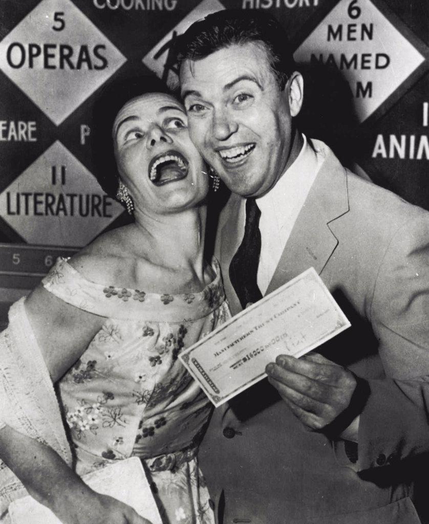 He-Quits A-Winner - Redmond O'Hanlon, New York City policeman, and his wife, Marguerite, mother of their five children, have good reason to be Jubilant tonight. O'Hanlon holds cashier's check for $16,000 in a television studio after winning that amount on his knowledge of Shakespeare on TV quiz show. He had dilemma of attempting another question on Shakespeare to double the amount. He elected instead to take the money, explaining a "father's conservatism" won out over a scholar's egotism. June 21, 1955. (Photo by AP Wirephoto).