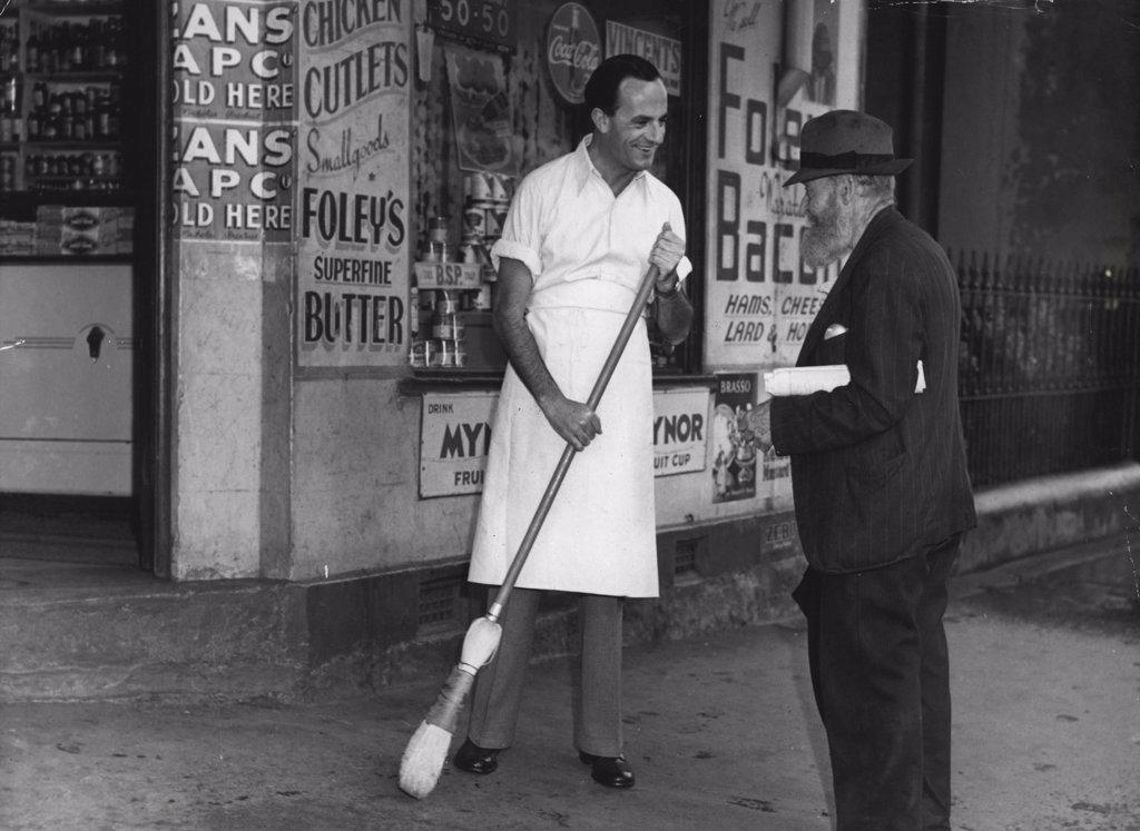 Early astir, this bearded old man stopped to chat about the wet morning while Lane was sweeping the footpath outside the shop. February 14, 1948.