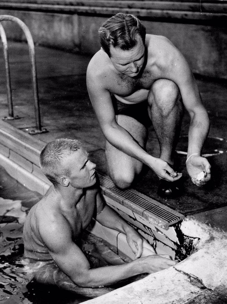 Coach, Harry Gallagher showing swimmer Jon Henricks his time taken during training at Drummoyne Today. January 18, 1955. (Photo by George Lipman/Fairfax Media)