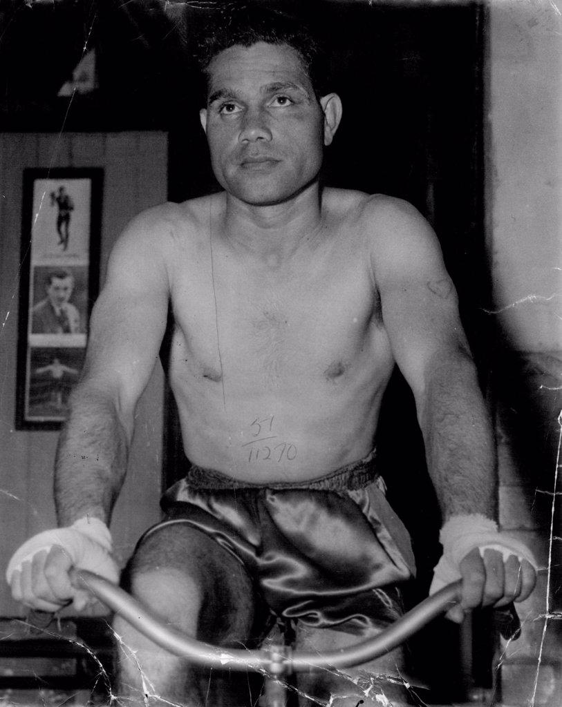 Australian lightweight champion Jack Hassen in training this week for his fight against welter champion Mick Tollis at the Stadium on Monday night.
He was an expressionless boxer, not winning when a blow got through and not saying anything as he sat upright in his corner between rounds. March 17, 1951. (Photo by Sporting Life).