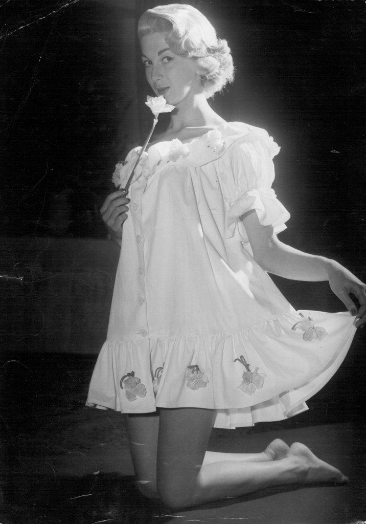 Janice Wakeley, 19, of West Ryde, models a short white cotton nightdress trimmed with pink and yellow tulips at "A Man's Idea of Spring" parade. 
Janice Wakeley, 19, of West Ryde models ***** for breakfast" a short white cotton ***** with pink and yellow tulips ***** on Fills the showed at "a ***** parade. September 23, 1955.