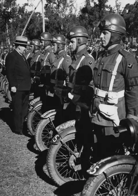 Army Policemen -- The Army Minister (Mr. Forde) inspecting members of the Provost Corps during his visit to an Australian Army camp in Queensland. Men of the corps have a multiplicity of duties, including the control of traffic in operational areas. Crash helmets are part of the equipment of these motor cyclists, and already have saved a number of them from serious injury. The corps has established a reputation for efficiency and speed in Australia and overseas. August 10, 1942.;Army Policemen -