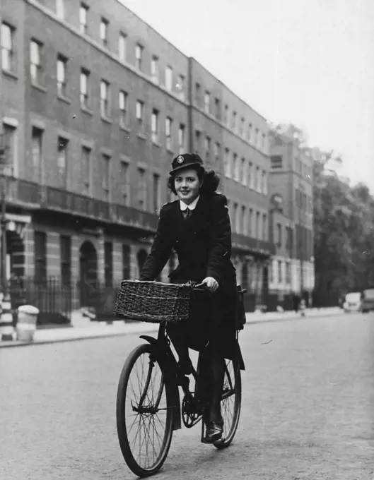 District Nurse Of Bloombsury -- Kathleen cycles off to work again along Bedford Place. Her bags go in a carrier at the back. March 24, 1948. (Photo by Pictorial Press).