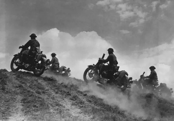 U.S. Soldier Cyclists Go "Over The Top" - Cumulus clouds above, dust clouds below United States motorcycle troops go "over the hump" in maneuvers somewhere in the United States. August 06, 1942. (Photo by Black Star).