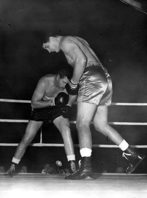 'Pottie' Dwars With Canadian Ewart (Pottie) Potgieter, 7ft 2in South African, gazes down at 6ft. 5in. Canadian James J. Parker in a clash at close quarters during their 10-round heavyweight contest at Harringay Arena, London, to-night (Tuesday). November 15, 1955. (Photo by Reuterphoto).