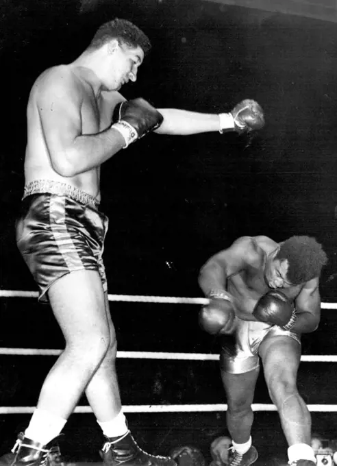 Giant south African Ewart Potgieter towers over Jamaican Simon Templar who submitted in the sixth at White City. September 21, 1955. (Photo by Sports and General Press Agency Limited)