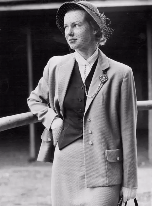 Elaine Blanshard, always a fashion leader, wore a suit of English corded beige material with a jaunty chocolate waistcoat-her cravat was kept in place with a gold key chain. August 24, 1951. (Photo by David R. Jones).