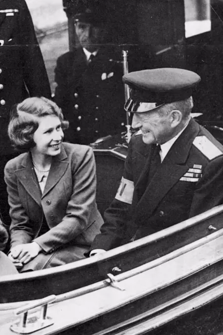 Princess On The Rever - A happy picture of Princess Elizabeth chatting with rear-admiral Sir Basil Brooke during the trip. Princess Elizabeth and Princess Margaret Rose had a break from lessons to day when they made a trip by launch on the Thames. January 21, 1943. (Photo by L.N.A.).