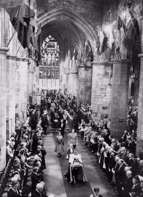 The Queen in St. Giles Cathedral. The ancient Crown of Scotland is carried on a cushion preceding the Queen and the Duke of Edinburgh in the St. Giles Cathedral here during the National Service of thanksgiving. The Queen and the Duke are currently making a State Visit to Scotland. June 25, 1953. (Photo by Planet News Ltd.).